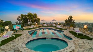 Piscina en la azotea con sillas de descanso y vistas del horizonte de la ciudad.