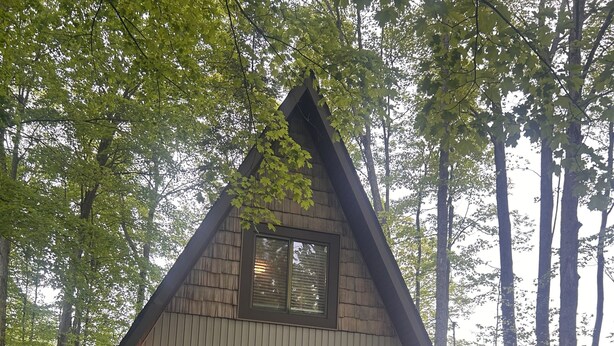 A modern A-frame cabin with a deck, large sliding glass doors, and a small porch area. - MCM A-frame: HOT TUB; Lake; Fall Colors; Fireplace; Nature; Cozy; Kayaks (Johannesburg)