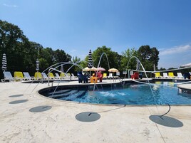 Una piscina al aire libre de temporada, sombrillas