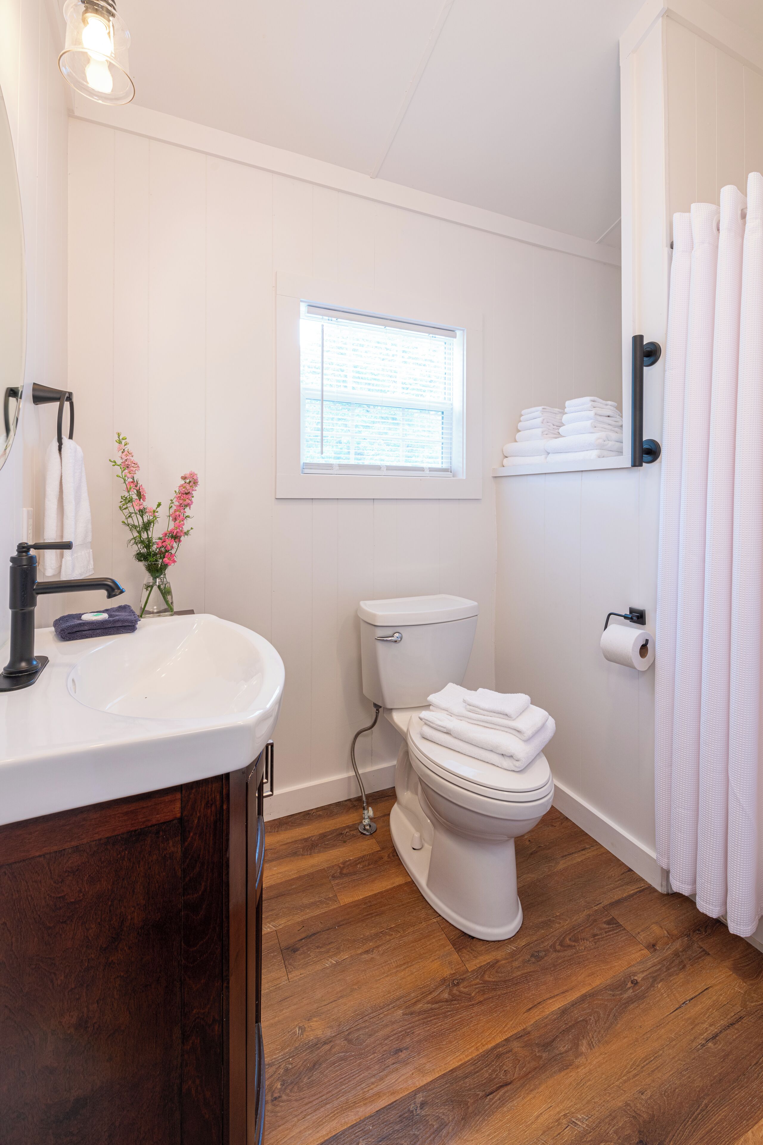 A bathroom with a white sink, toilet, and shower curtain.
