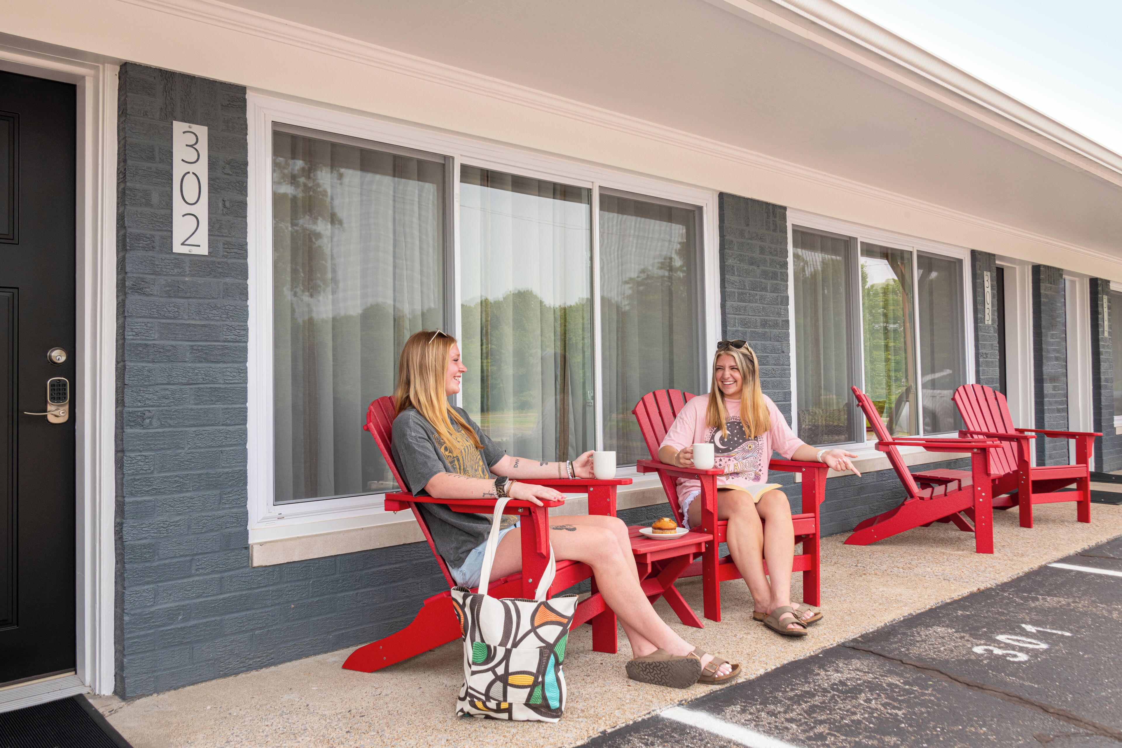 Two people seated at a table outside a building with a number 302 sign.