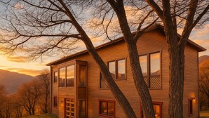 Een modern huis met twee verdiepingen, grote ramen, een zichtbare garage en een pad naar de ingang.