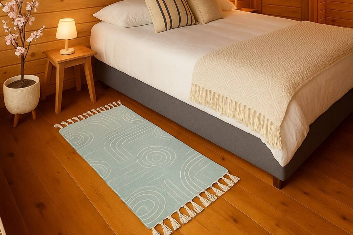 Un dormitorio acogedor de madera con una cama grande, dos mesitas de noche, una lámpara de pared y un adorno en la pared.