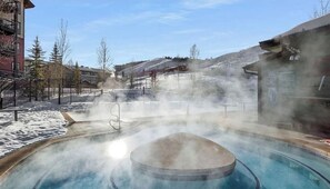 A hot spring area with a pool, surrounded by snow-covered ground and buildings. - Granby Ranch Condo-Hot Tub, Skiing, Trails & Lakes Nearby (Granby)