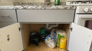 A kitchen with a built-in oven, a gas stove, and a cabinet with a wooden door. - Midtown Charm: 1BR Urban Pad (Reno)