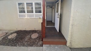 A small, single-story building with a narrow entrance and a mailbox on the left. - Midtown Charm: 1BR Urban Pad (Reno)