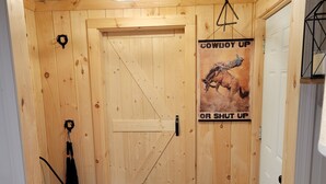 Un intérieur en bois avec une porte, une affiche et un banc.