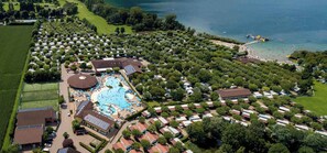 An aerial view of a campground with RVs, a swimming pool, and a beach area. - Mobilehome with terrace, air conditioning and pool (Fondotoce di Verbania)