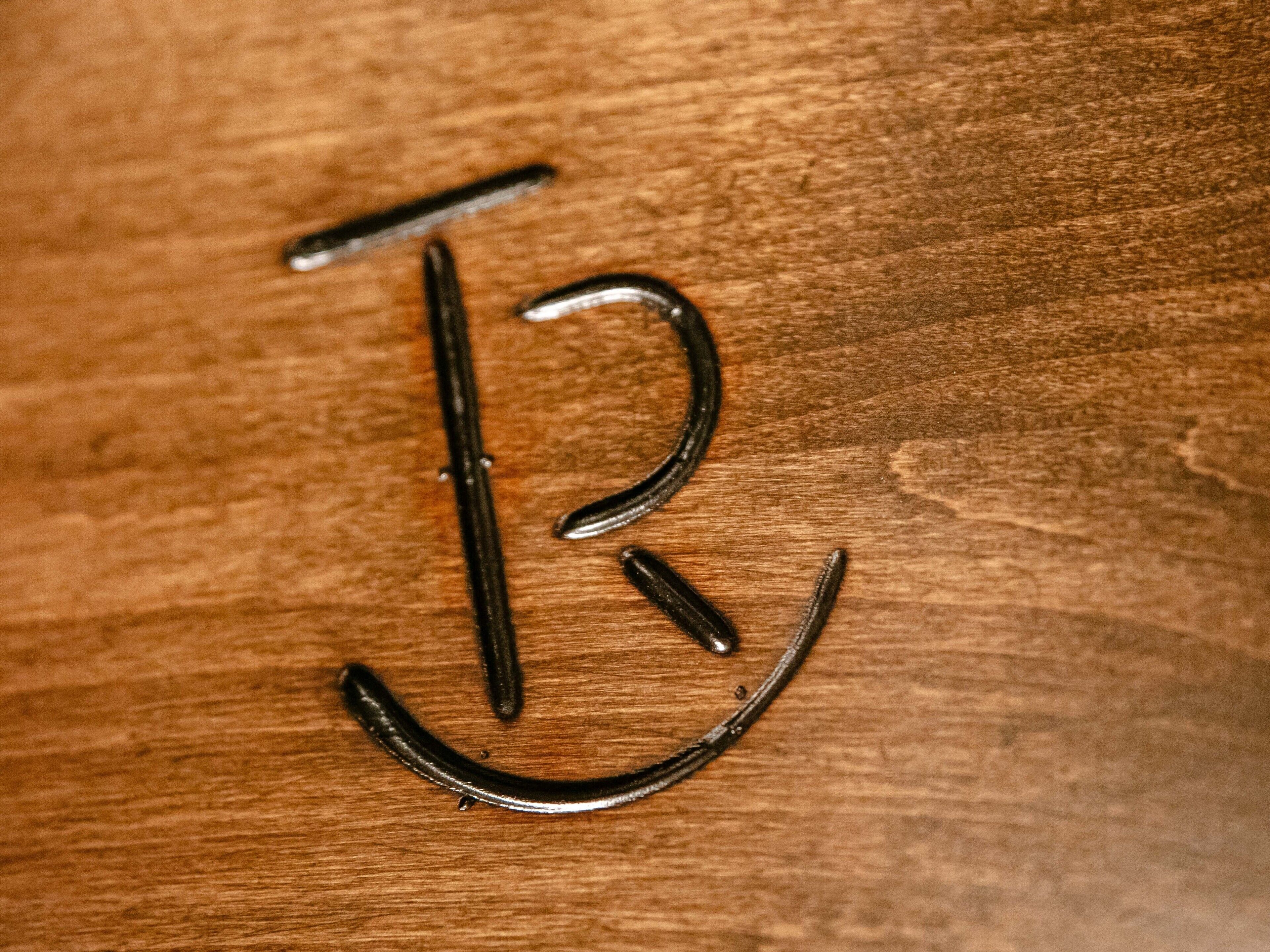 Three metal hooks on a wooden surface.