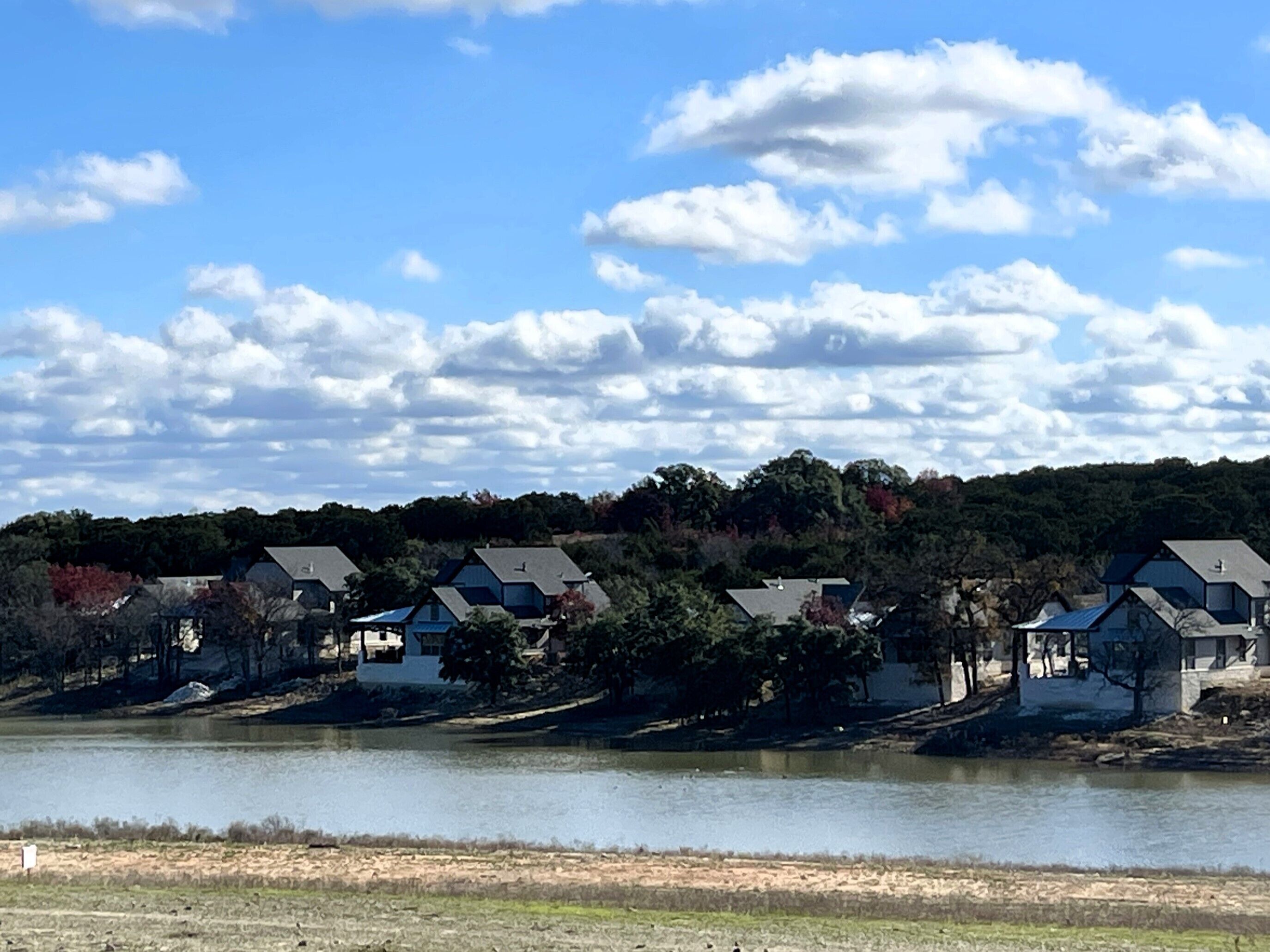 Filas de casas junto a un lago con cielo despejado.