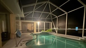 Ein Poolbereich mit Glasverkleidung, einem Liegestuhl und einer Geländer.