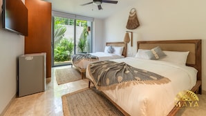 Quarto com cama, ventoinha no teto, televisão e frigorífico.