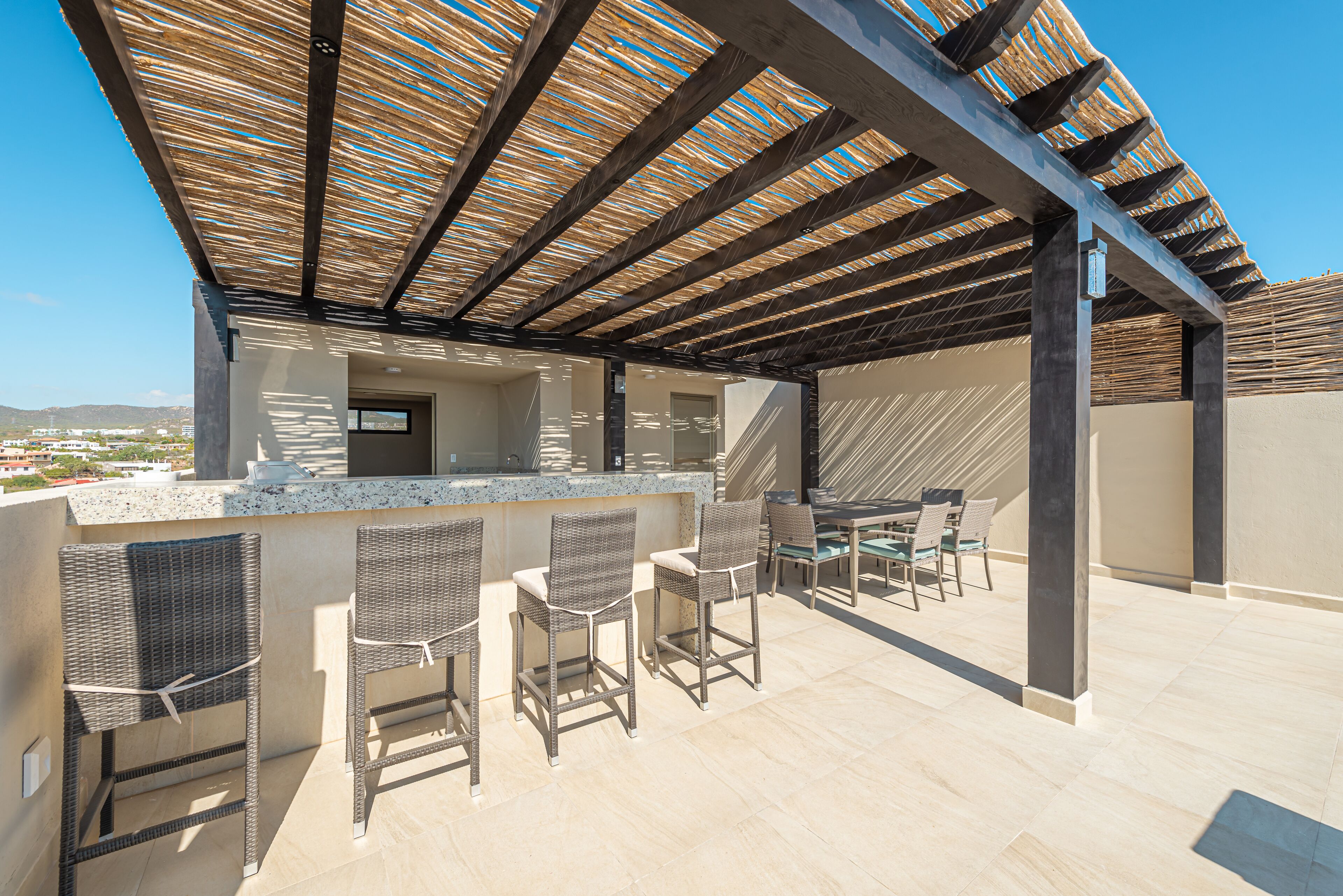 An outdoor bar area with wicker chairs and a bar counter.