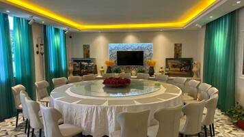 A round dining table with chairs, a central flower arrangement, and artwork on the walls.