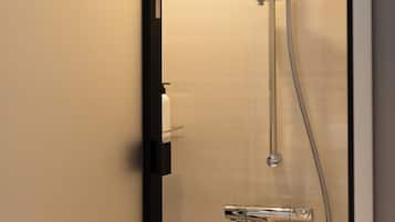 A modern shower with a handheld showerhead and a fixed showerhead, both with chrome finishes.