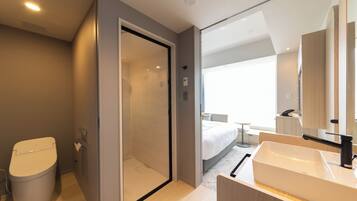 A modern bathroom with a toilet, shower, and sink.