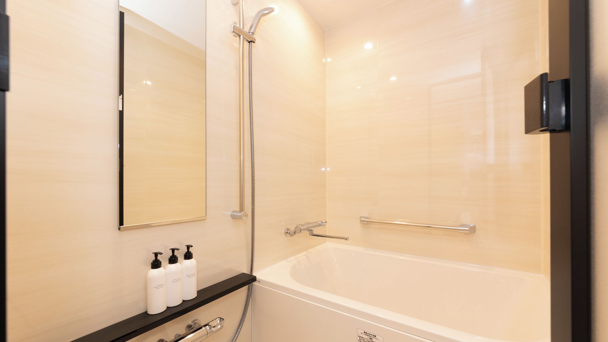 Une salle de bain moderne équipée d’une baignoire, d’une douche et d’un meuble-lavabo avec des articles de toilette.