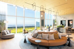 A modern living room with a large sofa, round coffee table, and dining area. - KEIKYU EX HOTEL MINATOMIRAI YOKOHAMA (Yokohama)