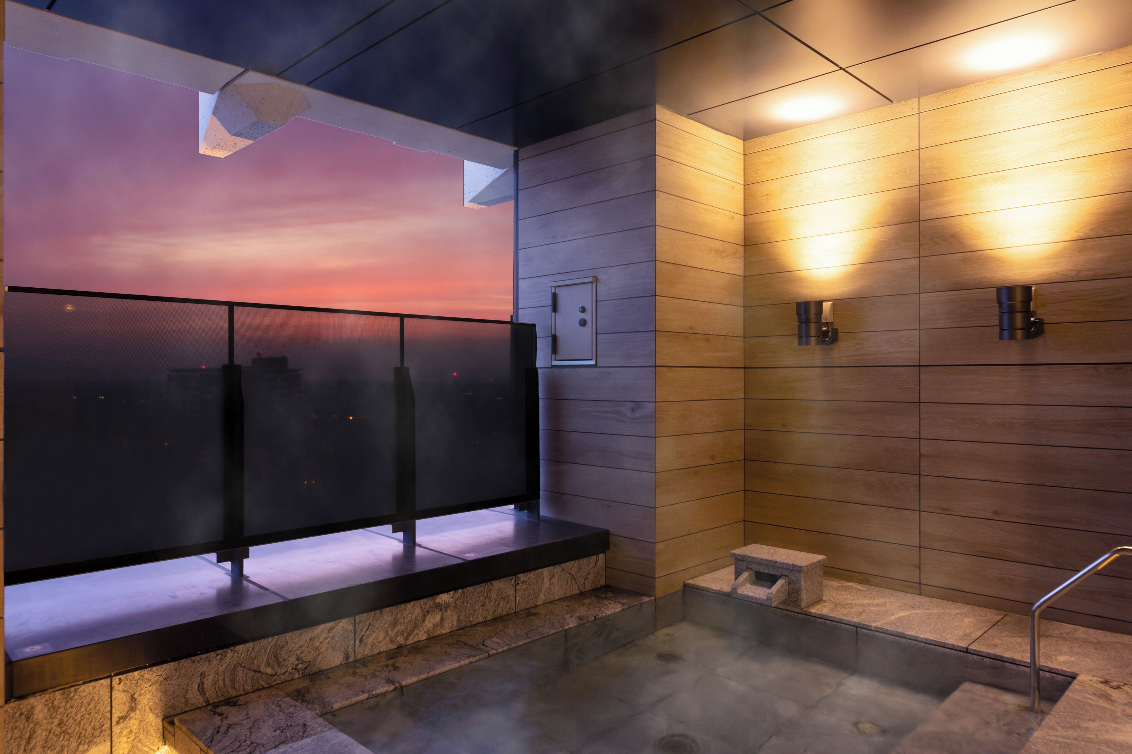 Een moderne badkamer met uitzicht op een zonsondergang, vloerverwarming en een klein opstapje naar de douche.