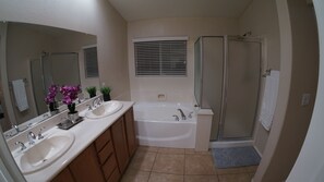 Tina con regadera, tina de hidromasaje, toallas, jabón 