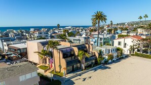Una zona residencial costera con casas modernas, una playa arenosa y una vista despejada del océano.
