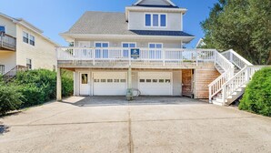 A two-story house with a balcony, a garage, and a staircase leading to a deck. - Mighty Duck: Hot Tub, Fire Pit, Game Room, Duck OBX (Duck)