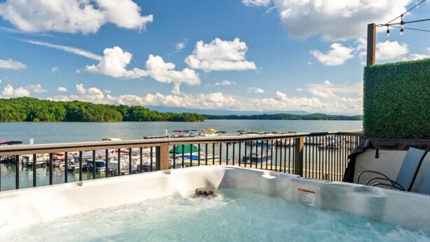 Un bain à remous avec vue sur un lac et des bateaux amarrés.