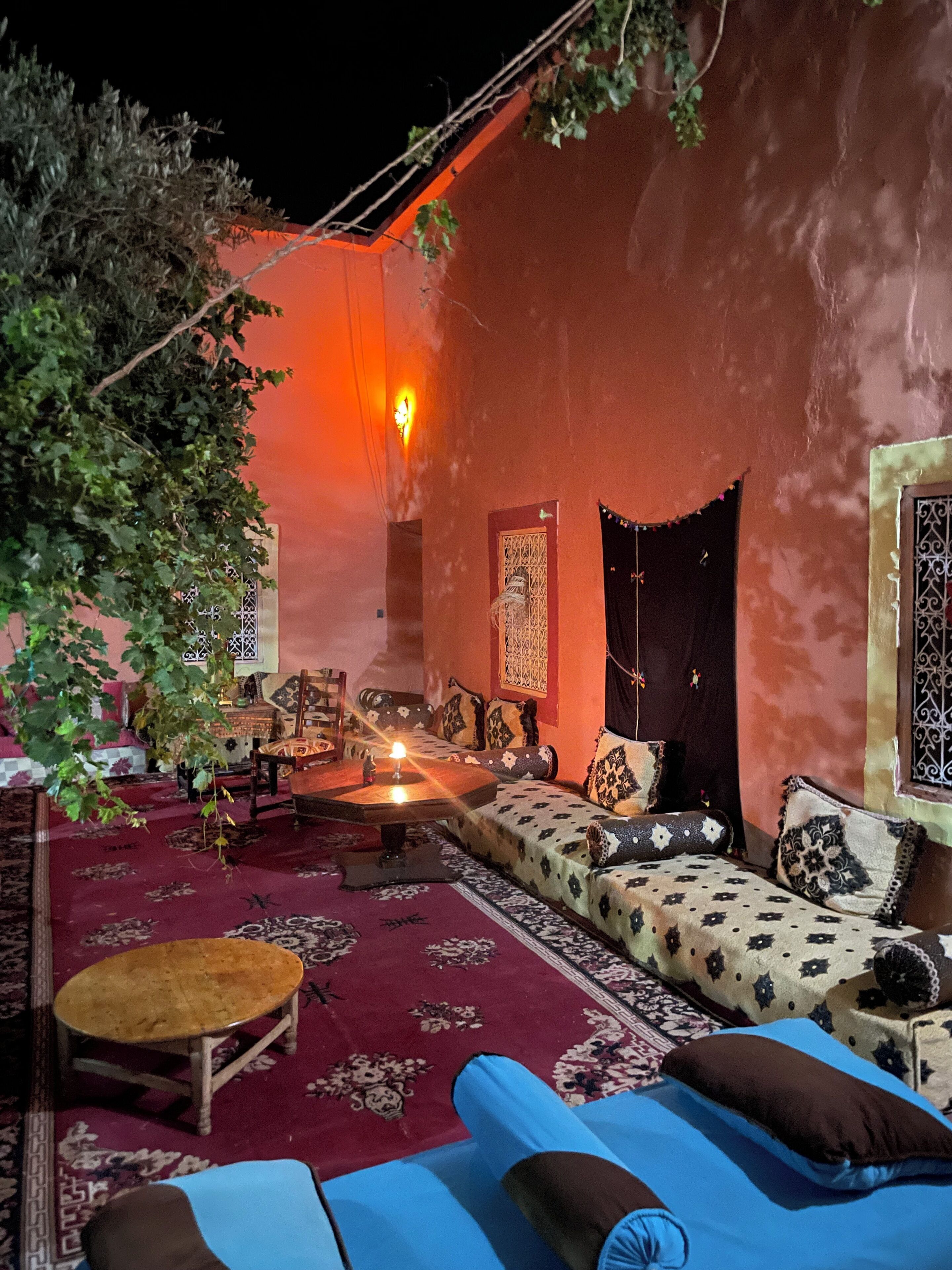 A cozy, dimly lit interior with a sofa, a small table, and a decorative lamp.