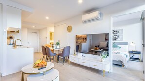 Una habitación moderna y luminosa con comedor, cocina y dormitorio.