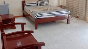 Un dormitorio con cama, escritorio y silla.