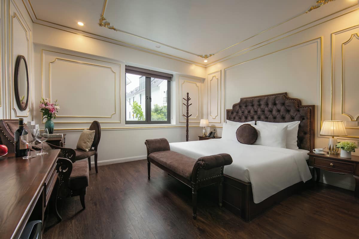 Deluxe kamer | Luxe beddengoed, een minibar met enkele gratis items, een bureau