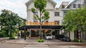 L’entrée d’un hôtel, avec une enseigne indiquant « ROYAL HOTEL ».