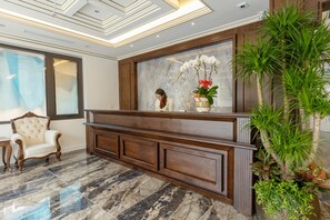 Welcome to our reception area, featuring a comfortable chair and a beautiful potted plant.