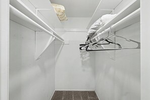 Una habitación estrecha con paredes blancas y un escalón que lleva a un nivel superior.