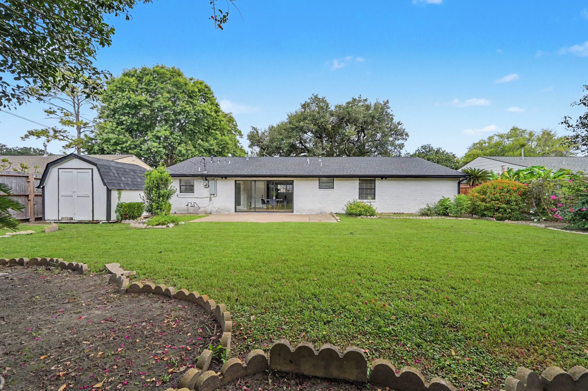 A single-story house with a front yard, a garage, and a small garden area.