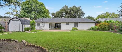 A single-story house with a front yard, a garage, and a small garden area.