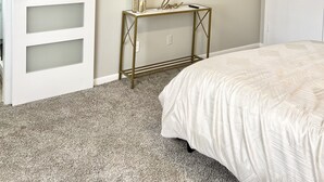 A bedroom with a bed, a TV mounted on the wall, a ceiling fan, and a sliding door. - Charming 3BR/2BA Near Galleria/NRG, Top Hospitals & LA Fitness (Houston)