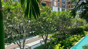 Un jardin luxuriant avec une piscine, entouré de bâtiments modernes.
