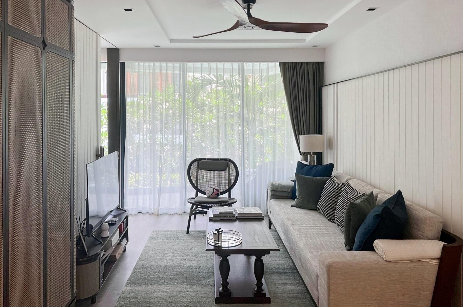 A modern living room with a sofa, a coffee table, a chair, and a TV.