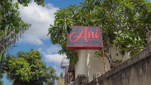 A sign for "Asri Guest House" with a clear view of the surrounding trees and sky. - Asri Guesthouse (Aik Berik)