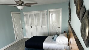 A bedroom with two beds, a ceiling fan, and a set of white doors. - SEAFLECTIONS - Relax, Reflect & Reminisce on the MUSIC, ART and CULTURE.  (Kingston)