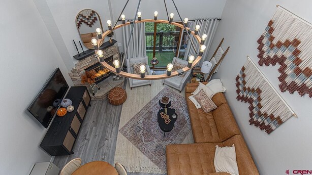 Una sala moderna con chimenea, un gran candelabro y vistas al exterior.