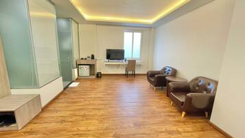 Deluxe Quadruple Room, 2 Queen Beds | Living area | TV