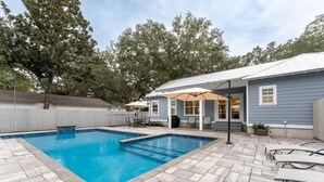 A backyard with a swimming pool, patio furniture, and a covered seating area. - Luxury St. Simons Island Vacation Rental | Private Pool Near Pier Village (Saint Simons Island)