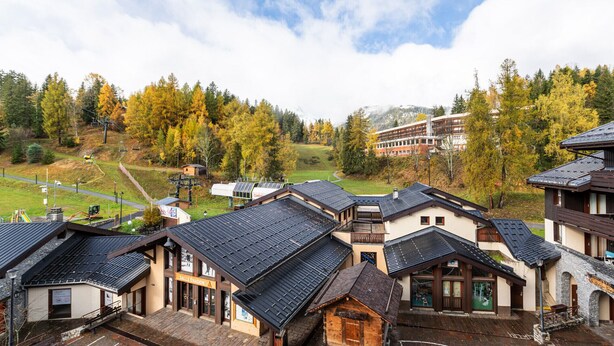 Il s’agit d’un bâtiment de style chalet traditionnel, doté d’un toit à forte pente, d’une façade en bois et d’un panneau indiquant la zone desservie par un télésiège.