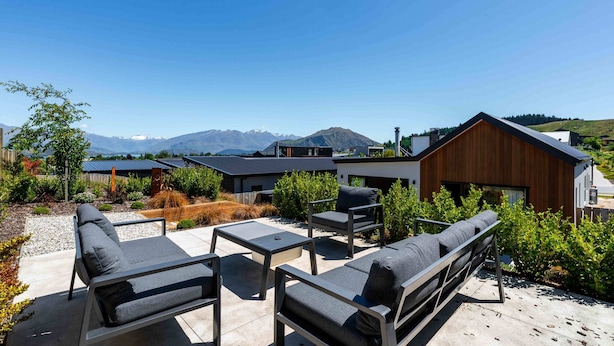 A modern outdoor seating area with a view of mountains and a lake. - Sunset Peaks Wanaka T (Wānaka)