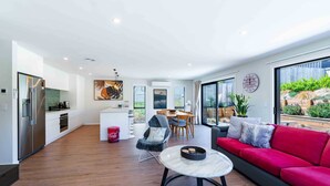 A modern living space with a kitchen, dining area, and seating area. - Sunset Peaks Wanaka T (Wānaka)