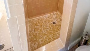 A small, tiled shower area with a drain in the center. - Poolside studio in the Foothills with Pool + Hot tub
 (Tucson)