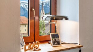 Een raam met houten kader, een bureau met lamp, een fotolijst en houten letters die 'LAAS' vormen.