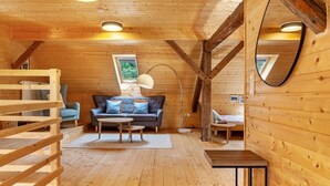 Un interior de madera con un sofá, una mesa de centro y un espejo.